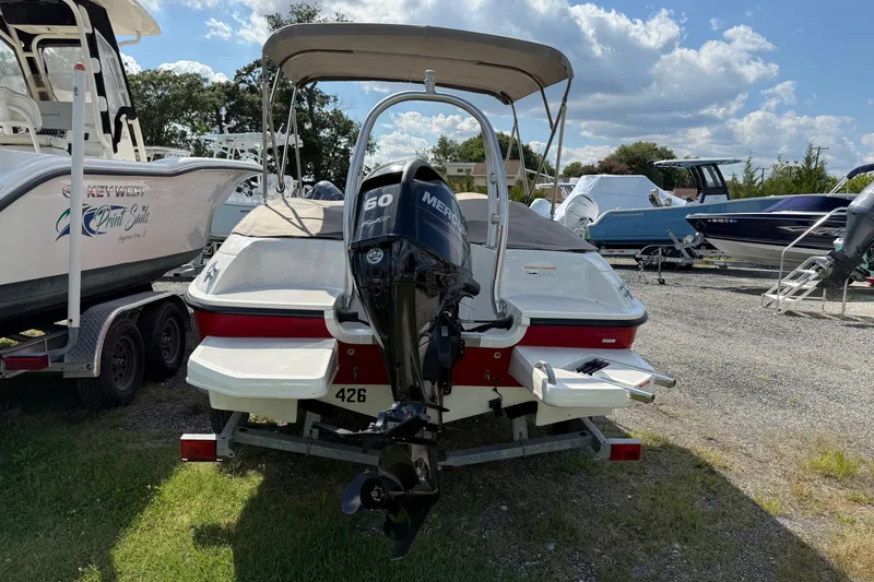 Slide: The Image of 2013 Bayliner Element boat with Mercury 60 engine, parked outdoors under a sunny sky. - 6