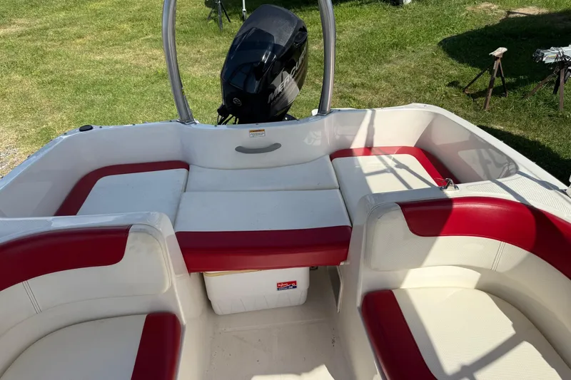 Slide: The Image of 2013 Bayliner Element boat interior with red and white seating, outdoor setting. - 9