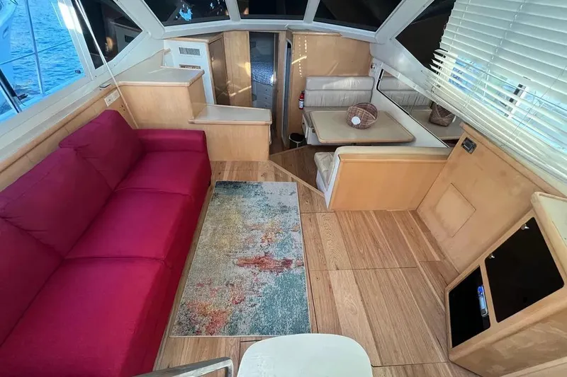 Slide: The Image of Interior of 1998 Carver 355 Aft Cabin with red sofa and dining area. - 14