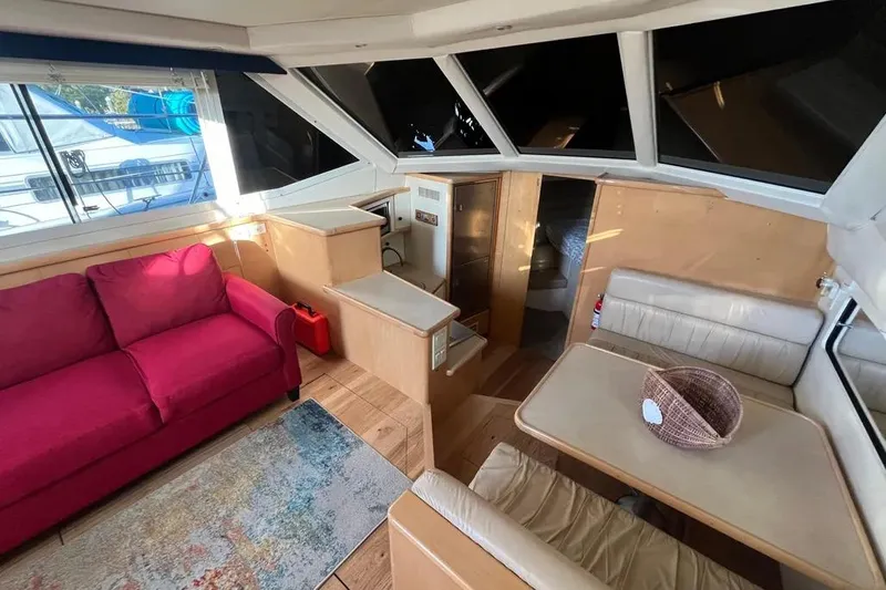 Slide: The Image of Interior of 1998 Carver 355 Aft Cabin with red sofa and dining area. - 15