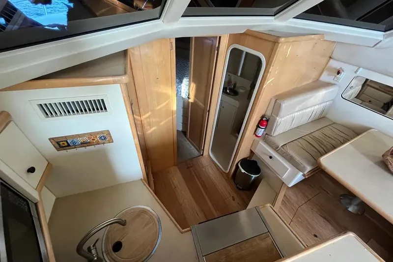 Slide: The Image of Interior of 1998 Carver 355 Aft Cabin yacht with wood finishes and seating area. - 16