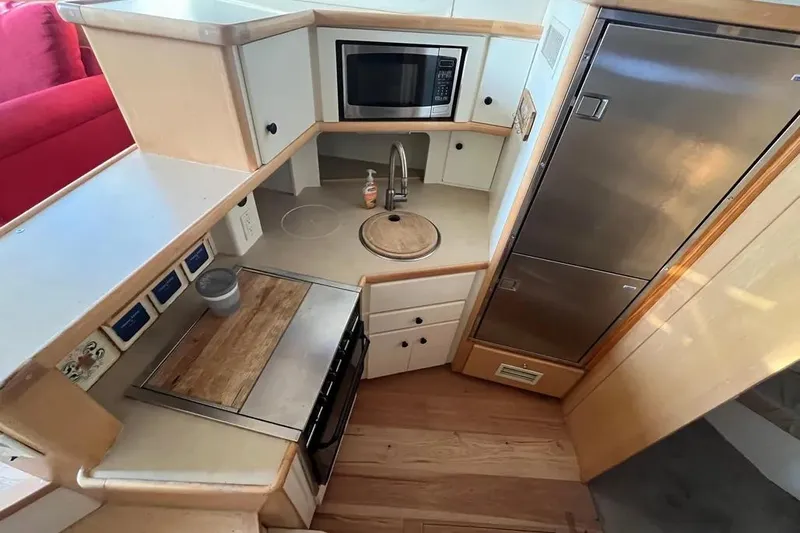 Slide: The Image of 1998 Carver 355 Aft Cabin kitchen with microwave, sink, and refrigerator. - 17