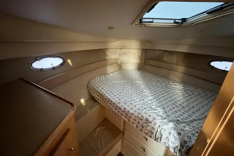 Slide: The Image of 1998 Carver 355 Aft Cabin interior with bed, portholes, and overhead hatch. - 19