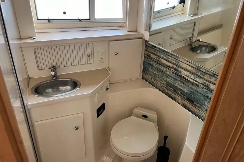Slide: The Image of 1998 Carver 355 Aft Cabin bathroom with sink, toilet, and mirror. - 23