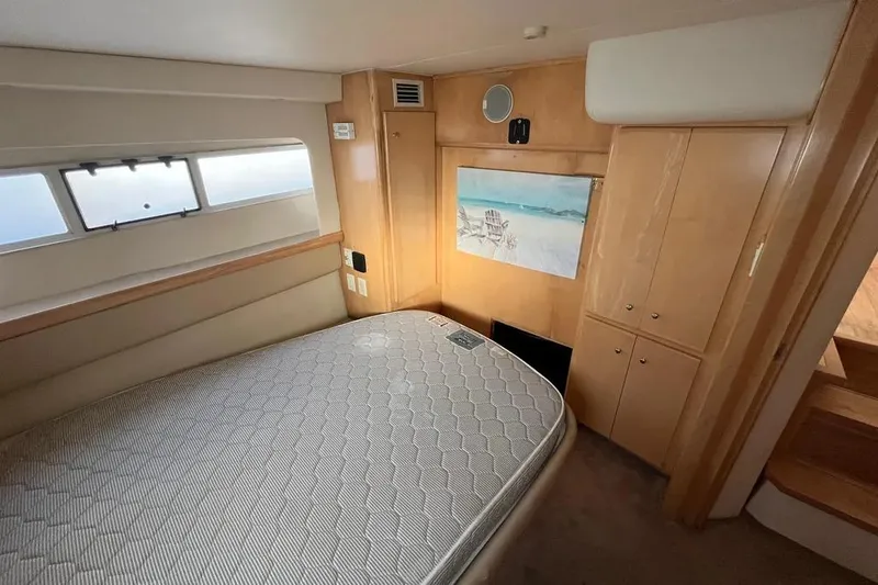 Slide: The Image of 1998 Carver 355 Aft Cabin bedroom with bed, window, and wooden cabinetry. - 24