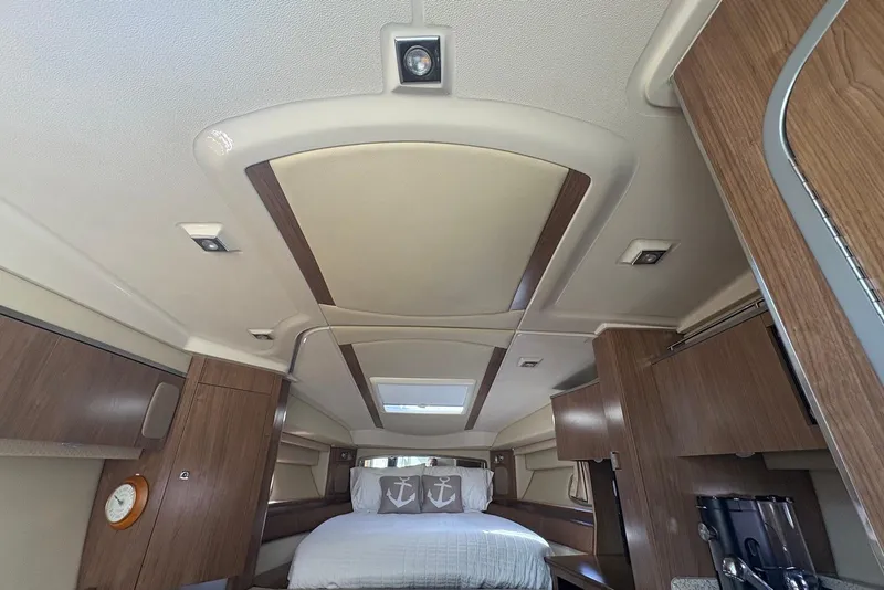 Slide: The Image of Interior of 2011 Chaparral 330 Signature yacht with wood accents and cozy sleeping area. - 22