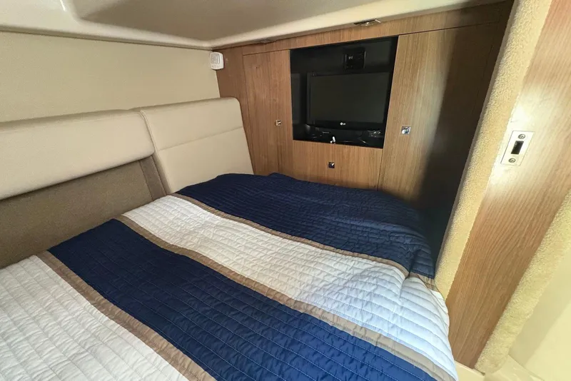 Slide: The Image of 2011 Chaparral 330 Signature cabin interior with bed and wall-mounted TV. - 25