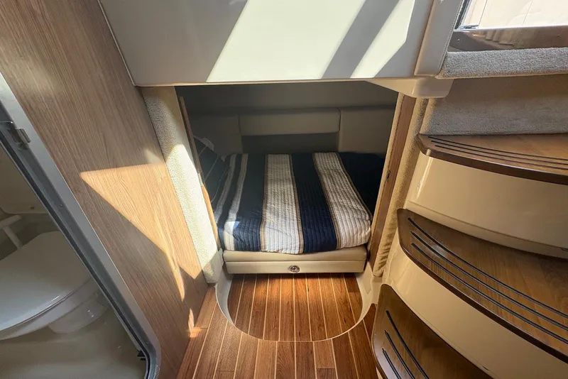 Slide: The Image of 2011 Chaparral 330 Signature cabin interior with bed, wooden flooring, and stairs. - 27