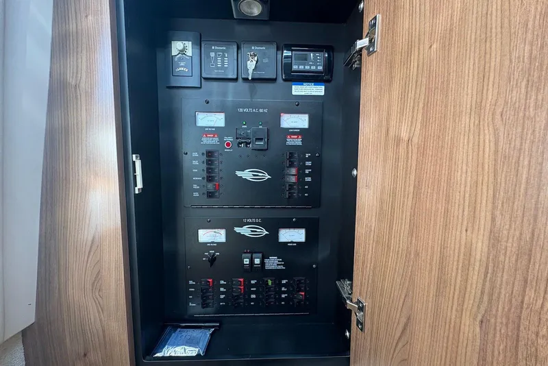 Slide: The Image of Electrical panel inside 2011 Chaparral 330 Signature boat, featuring various switches and meters. - 30