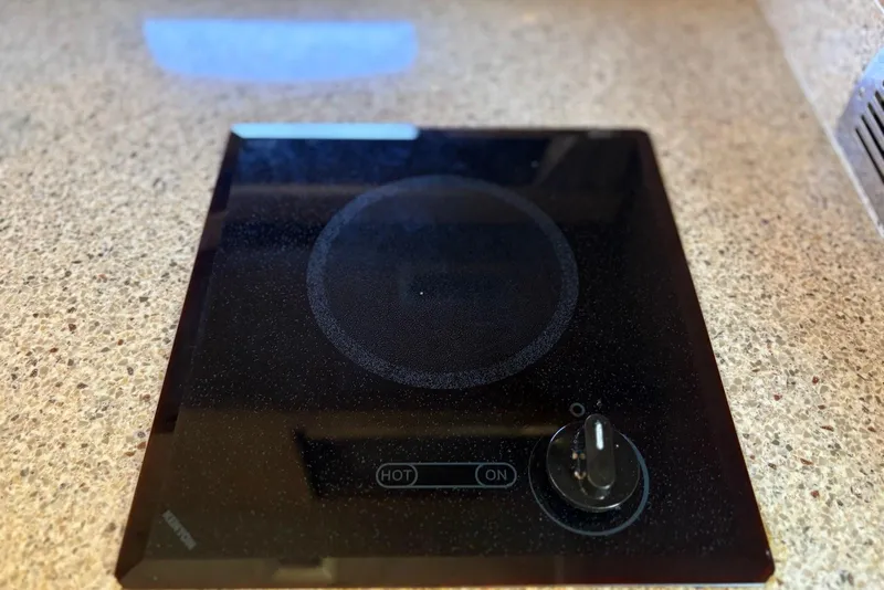 Slide: The Image of Electric stove on Chaparral 330 Signature 2011 boat, featuring a sleek black cooktop. - 36