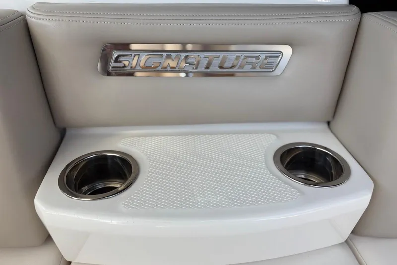 Slide: The Image of 2011 Chaparral 330 Signature boat interior with cup holders and "Signature" emblem. - 38