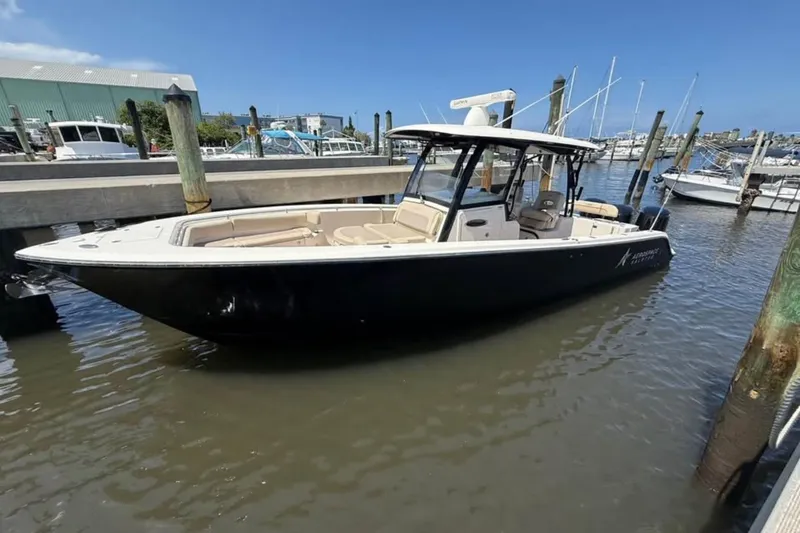 The Image of 2015 Cobia 344 Center Console boat docked in marina, clear sky background. - 1