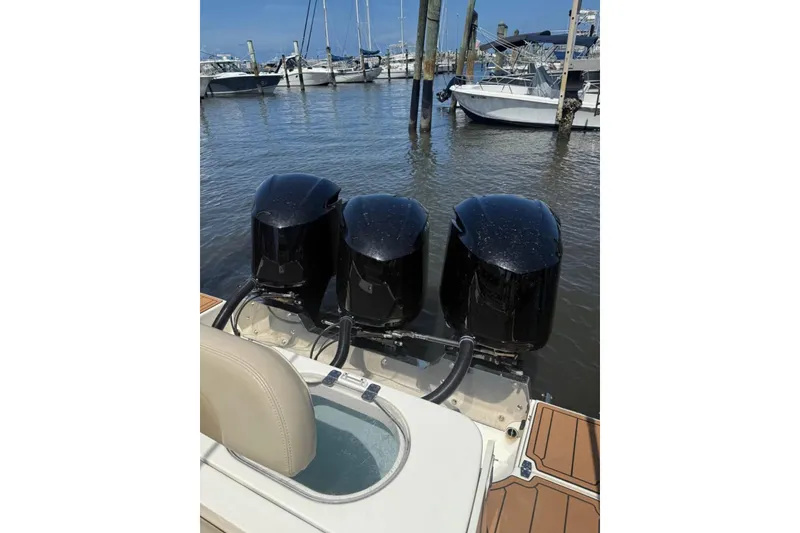 Slide: The Image of 2015 Cobia 344 Center Console with triple outboard engines at marina. - 5