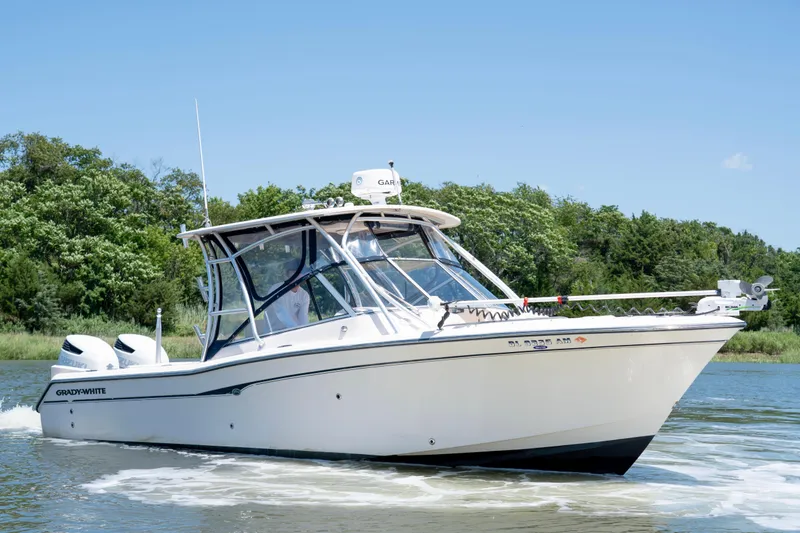 The Image of 2007 Grady-White Tournament 275 boat cruising on a sunny day near lush greenery. - 0