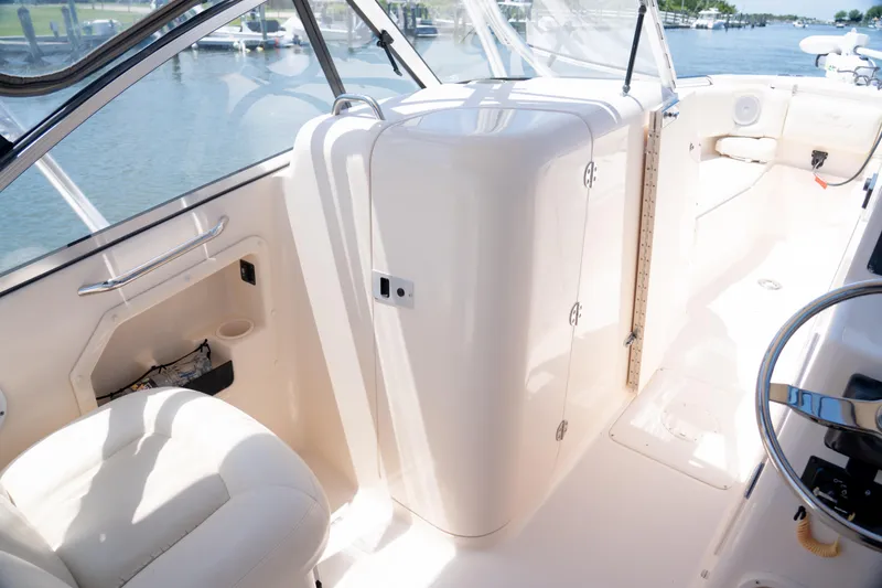 Slide: The Image of 2007 Grady-White Tournament 275 boat interior with seating and helm, docked by the water. - 11