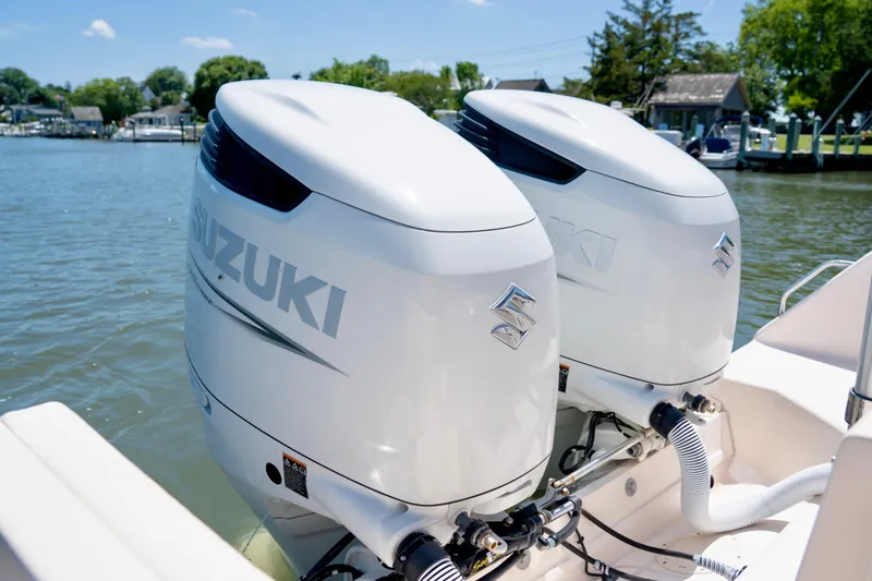 Slide: The Image of Twin Suzuki outboard motors on a 2007 Grady-White Tournament 275 boat, docked by the water. - 6