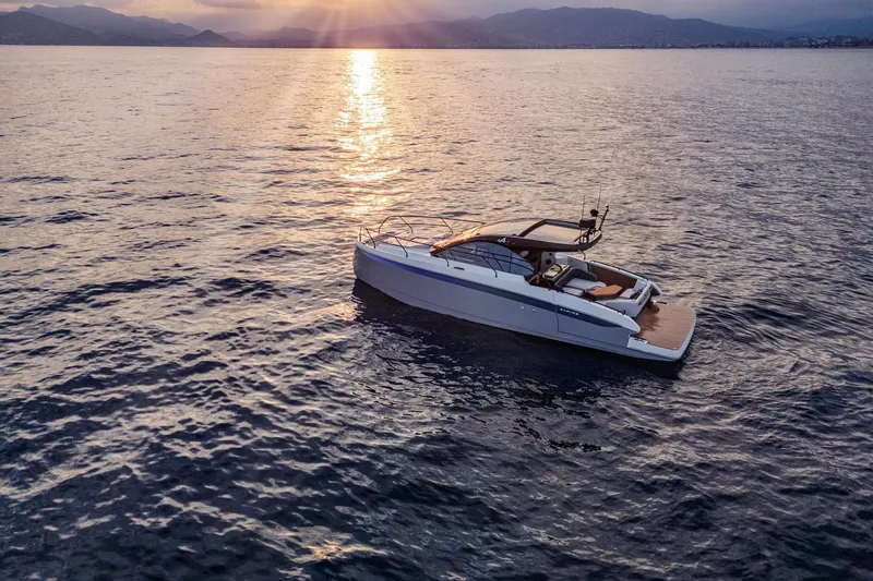 Slide: The Image of 2026 Beneteau Gran Turismo 40 yacht on serene water at sunset. - 22