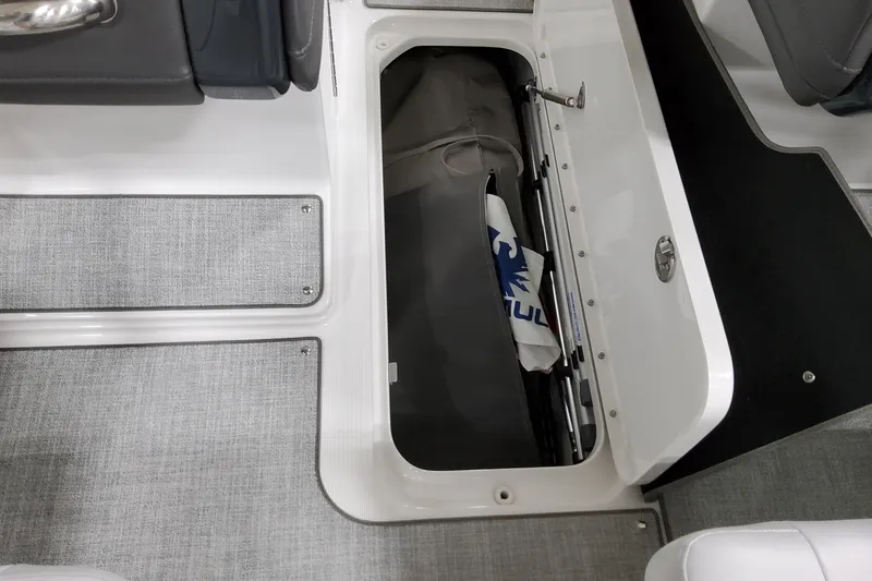 Slide: The Image of 2026 Formula 240 Bowrider storage compartment with gray flooring and seating. - 30