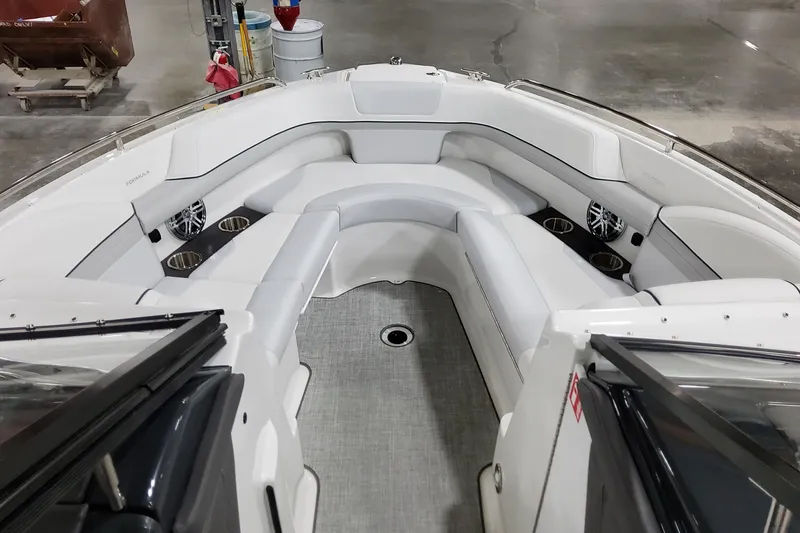 Slide: The Image of 2026 Formula 240 Bowrider interior with white seating and cup holders in a showroom. - 34