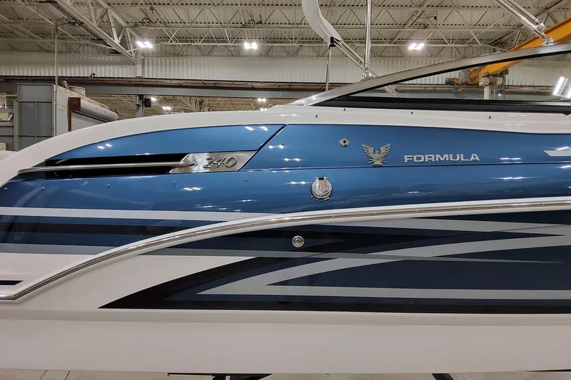 Slide: The Image of 2026 Formula 240 Bowrider boat in a showroom, featuring sleek blue and white design. - 4
