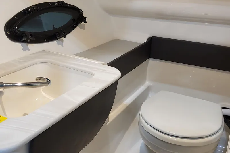 Slide: The Image of 2026 Formula 270 Bowrider bathroom with sink, toilet, and porthole window. - 16