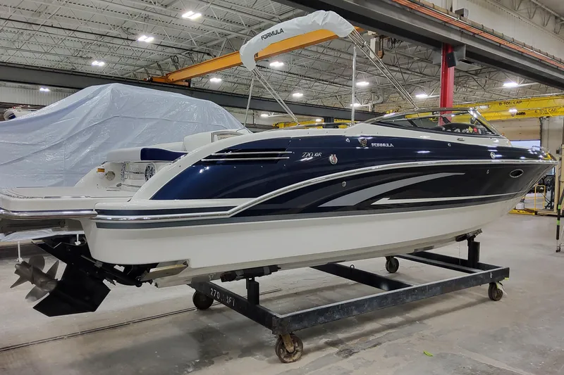 Slide: The Image of 2026 Formula 270 Bowrider boat in a warehouse, sleek design with blue and white finish. - 4