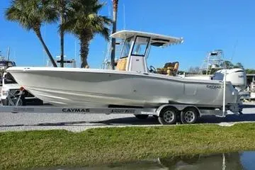 The Image of 2026 Caymas 291 boat on trailer, parked near palm trees and water. - 0