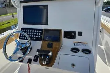 Slide: The Image of 2026 Caymas 291 boat dashboard with steering wheel, controls, and display screens. - 4