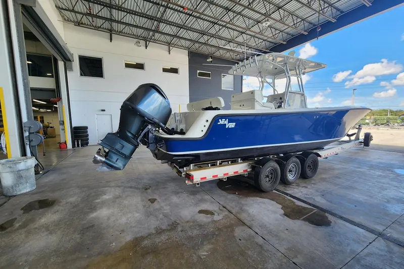 Slide: The Image of 2012 SeaVee 340B boat on trailer in a garage, featuring a blue hull and outboard motor. - 3