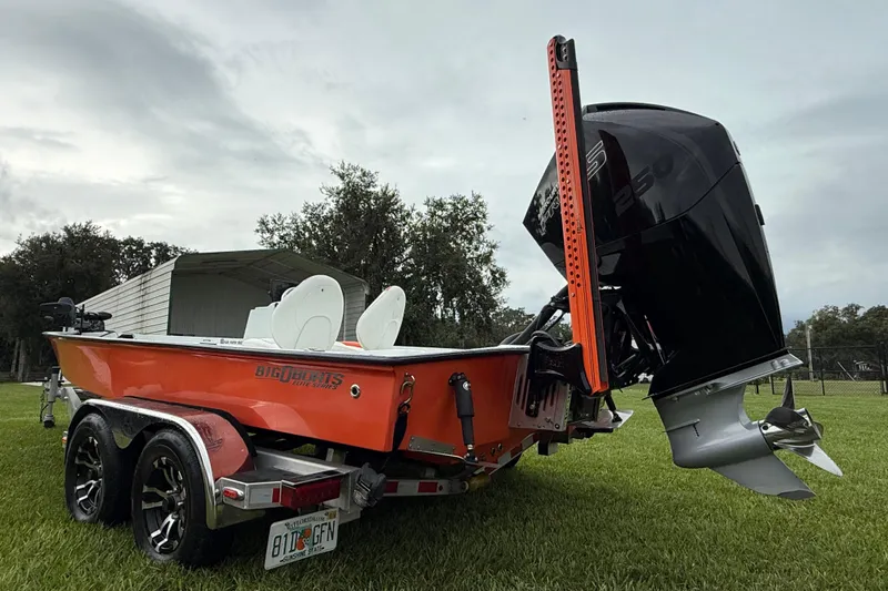 Slide: The Image of Orange Big O Elite 20 boat, 2021 model, with powerful outboard motor on grassy field. - 12