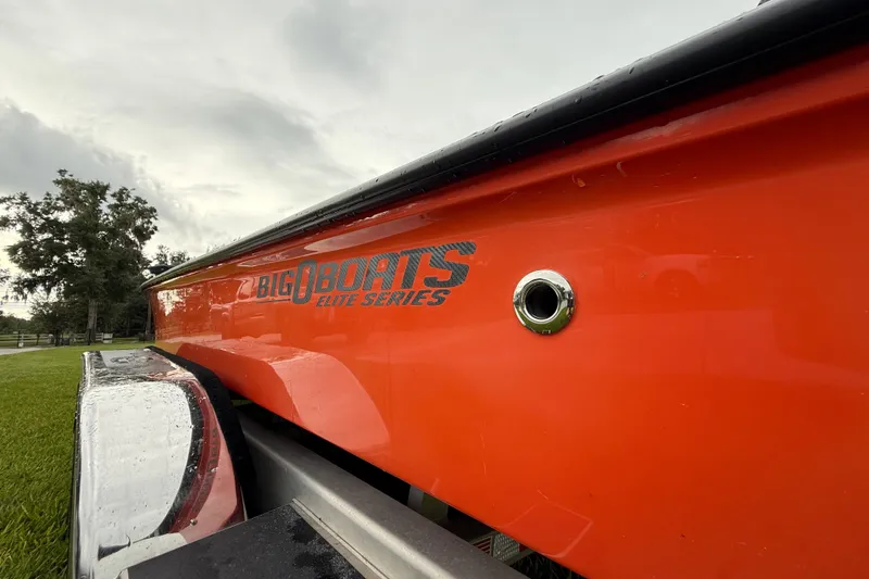 Slide: The Image of Orange Big O Elite 20 boat on trailer, side view, showcasing logo and sleek design. - 13
