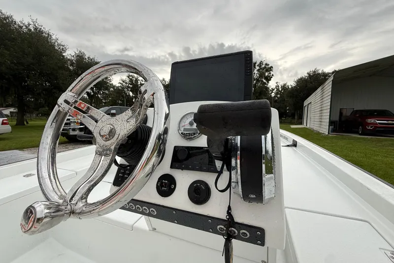 Slide: The Image of Steering console of 2021 Big O Elite 20 boat with chrome wheel and controls. - 15