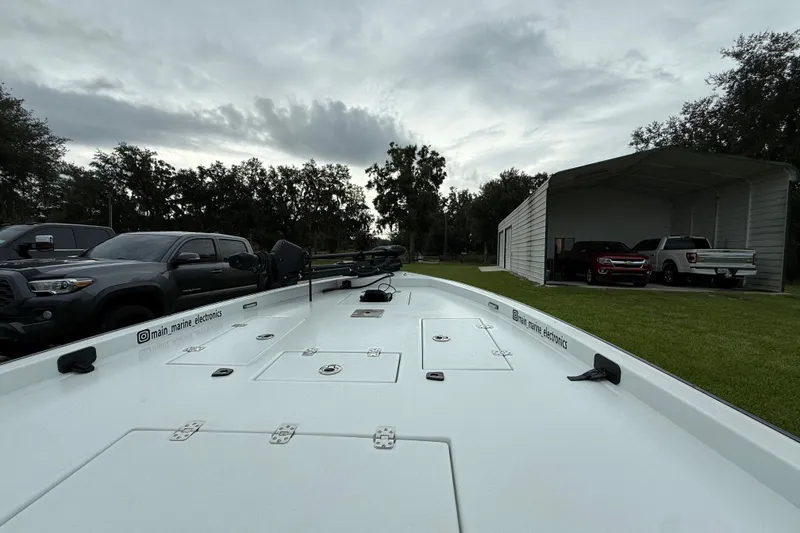 Slide: The Image of 2021 Big O Elite 20 boat on trailer, parked near trucks and a garage. - 16