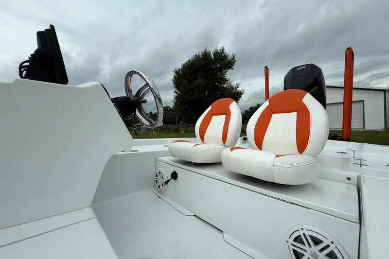 Slide: The Image of Interior of 2021 Big O Elite 20 boat with orange and white seats, steering wheel, and speakers. - 19