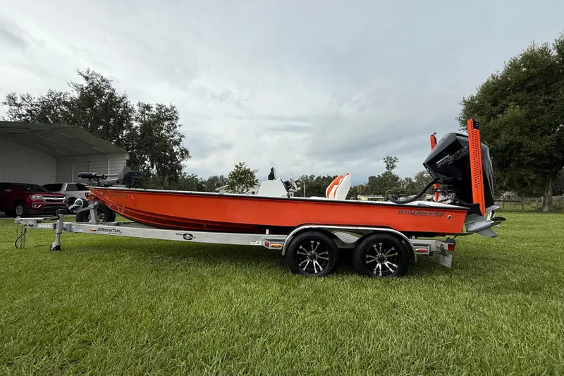 Slide: The Image of Orange Big O Elite 20 boat on trailer, grassy field, overcast sky, 2021 model. - 2