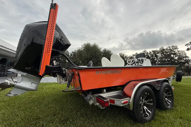 Slide: The Image of Orange Big O Elite 20 boat, 2021 model, on a grassy area with dual wheels and powerful engine. - 22