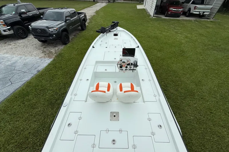 Slide: The Image of 2021 Big O Elite 20 boat with dual seats, parked near trucks on grass. - 23
