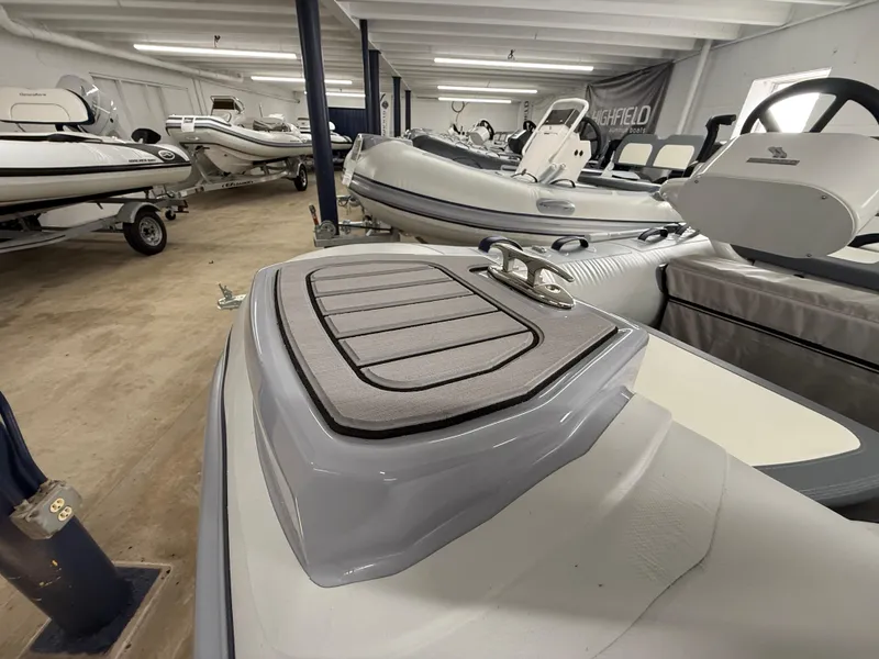 Slide: The Image of 2025 Highfield Classic 310 FCT boat in showroom, featuring sleek design and modern seating. - 10