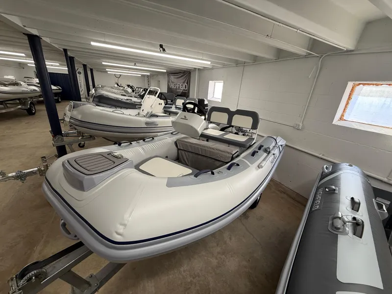 Slide: The Image of 2025 Highfield Classic 310 FCT inflatable boat in showroom, showcasing sleek design and features. - 2