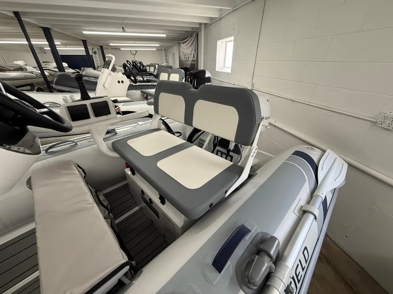 Slide: The Image of 2025 Highfield Classic 310 FCT boat interior with dual seating in showroom. - 3