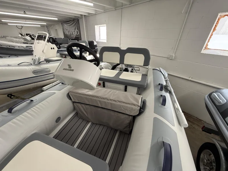 Slide: The Image of 2025 Highfield Classic 310 FCT inflatable boat interior with steering console and seating. - 9