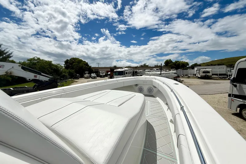 Slide: The Image of 2023 Contender 39 Fisharound boat with sleek white deck under a partly cloudy sky. - 15