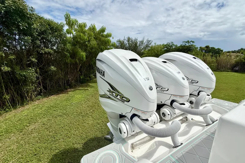 Slide: The Image of Triple Yamaha outboard engines on a 2023 Contender 39 Fisharound boat, parked on grass. - 16