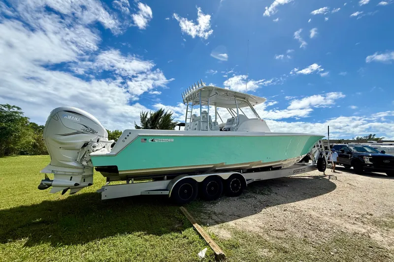 Slide: The Image of 2023 Contender 39 Fisharound boat on trailer under clear blue sky. - 20