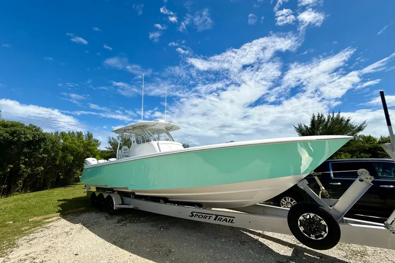 Slide: The Image of 2023 Contender 39 Fisharound boat on trailer under clear blue sky. - 3