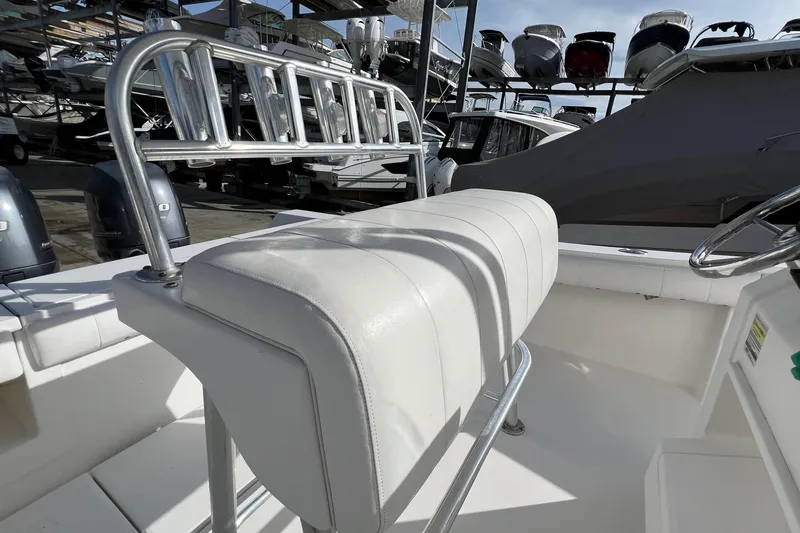 Slide: The Image of 2012 Regulator 24 Forward Seating boat interior with white cushioned seating and metal railings. - 10