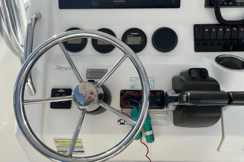 Slide: The Image of 2012 Regulator 24 Forward Seating boat dashboard with steering wheel and controls. - 15