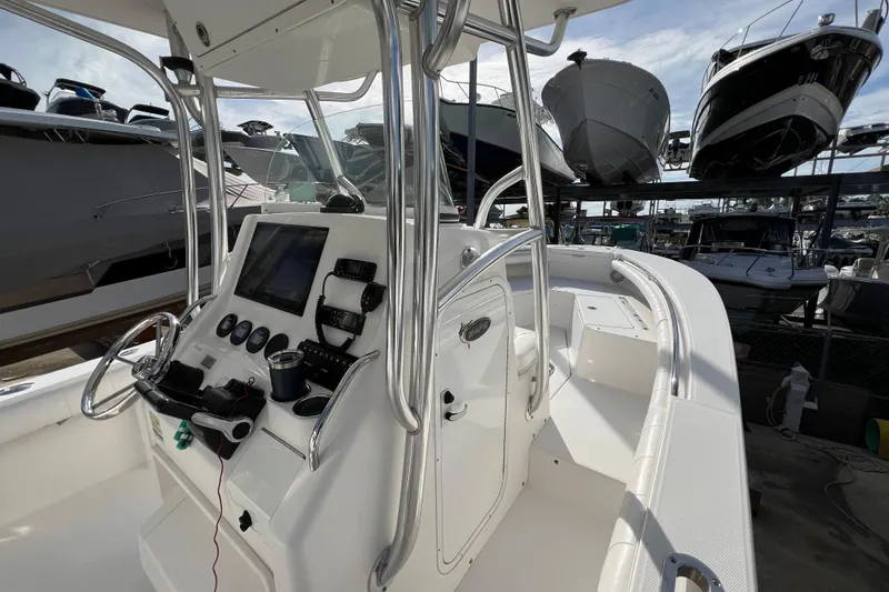 Slide: The Image of 2012 Regulator 24 Forward Seating boat with modern console and docked vessels in background. - 19