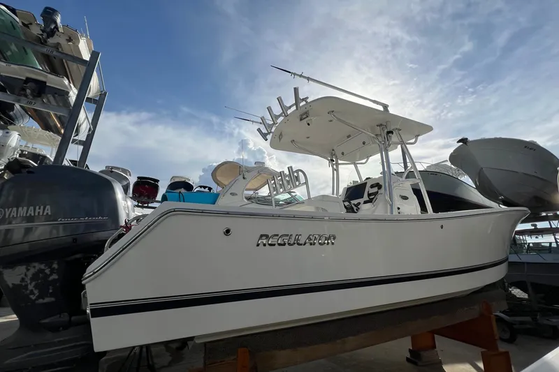 Slide: The Image of 2012 Regulator 24 Forward Seating boat on display, surrounded by other vessels under a bright sky. - 2