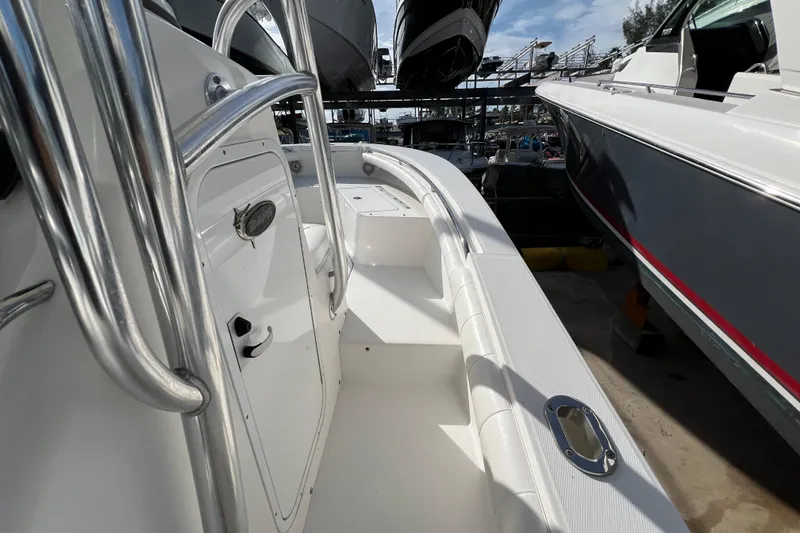 Slide: The Image of 2012 Regulator 24 Forward Seating boat, white interior, docked alongside other boats. - 20